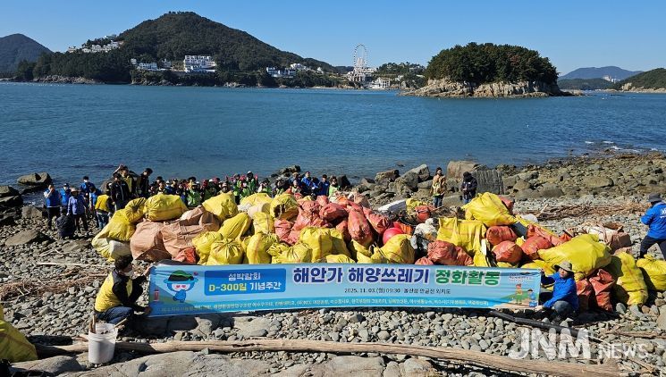 지난 3일 2026여수세계섬박람회 D-300 기념 해양 정화활동에 참여한 시민들이 돌산읍 외치도 해안에서 수거한 해양쓰레기와 함께 기념촬영을 하고 있다.