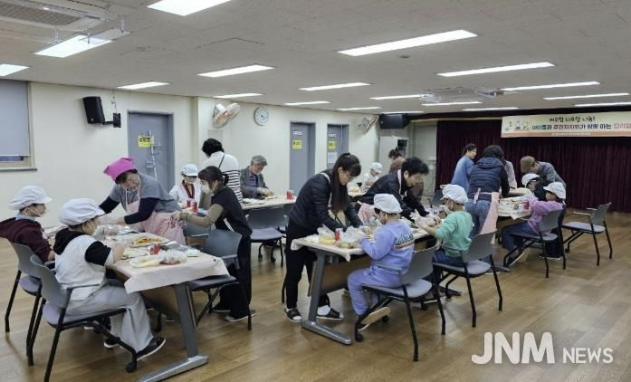 도봉1동 주민자치회 복지분과 회원들과 지역 아동들이 함께 김밥을 만들고 있다.