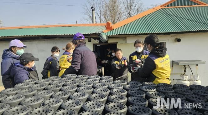 21일 봉사자들이 연탄을 트럭에 싣는 모습